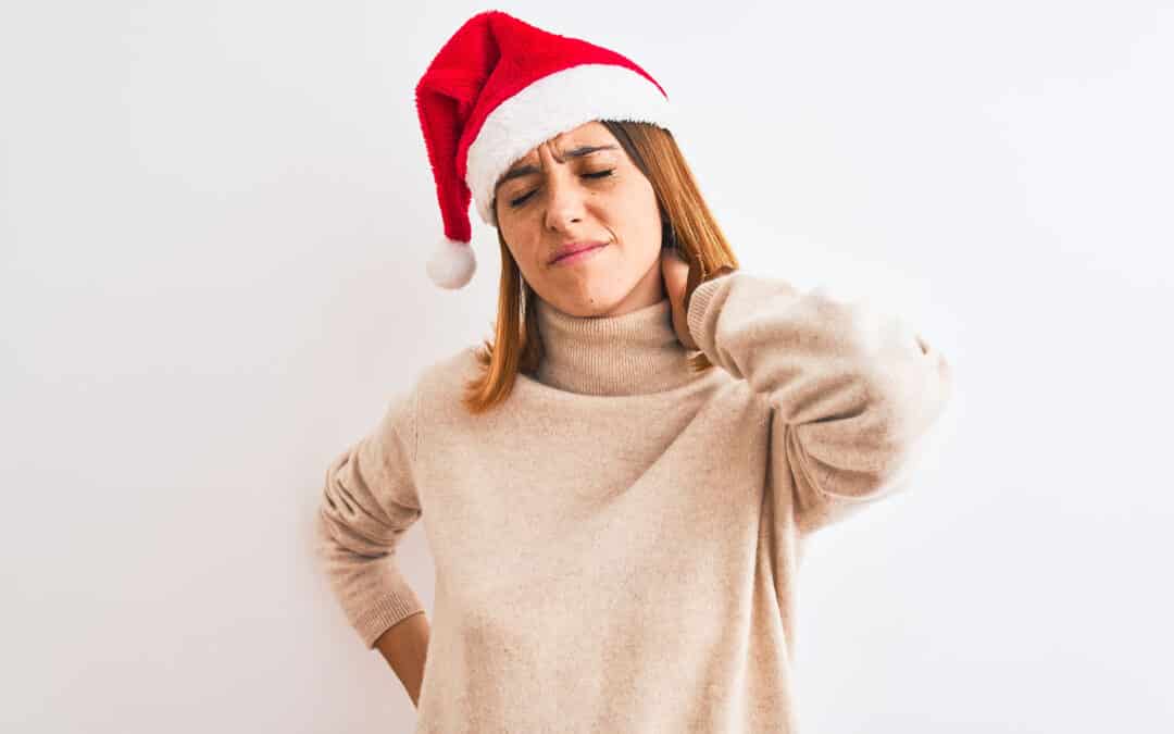 redhead woman wearing christmas hat over isolated background Suffering of neck ache injury, touching neck with hand, muscular pain