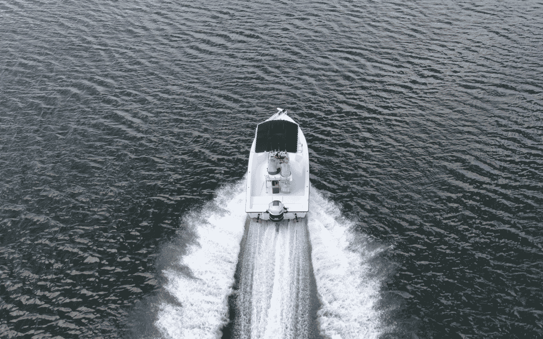 a boat moving through a large body of water - boating safety tips
